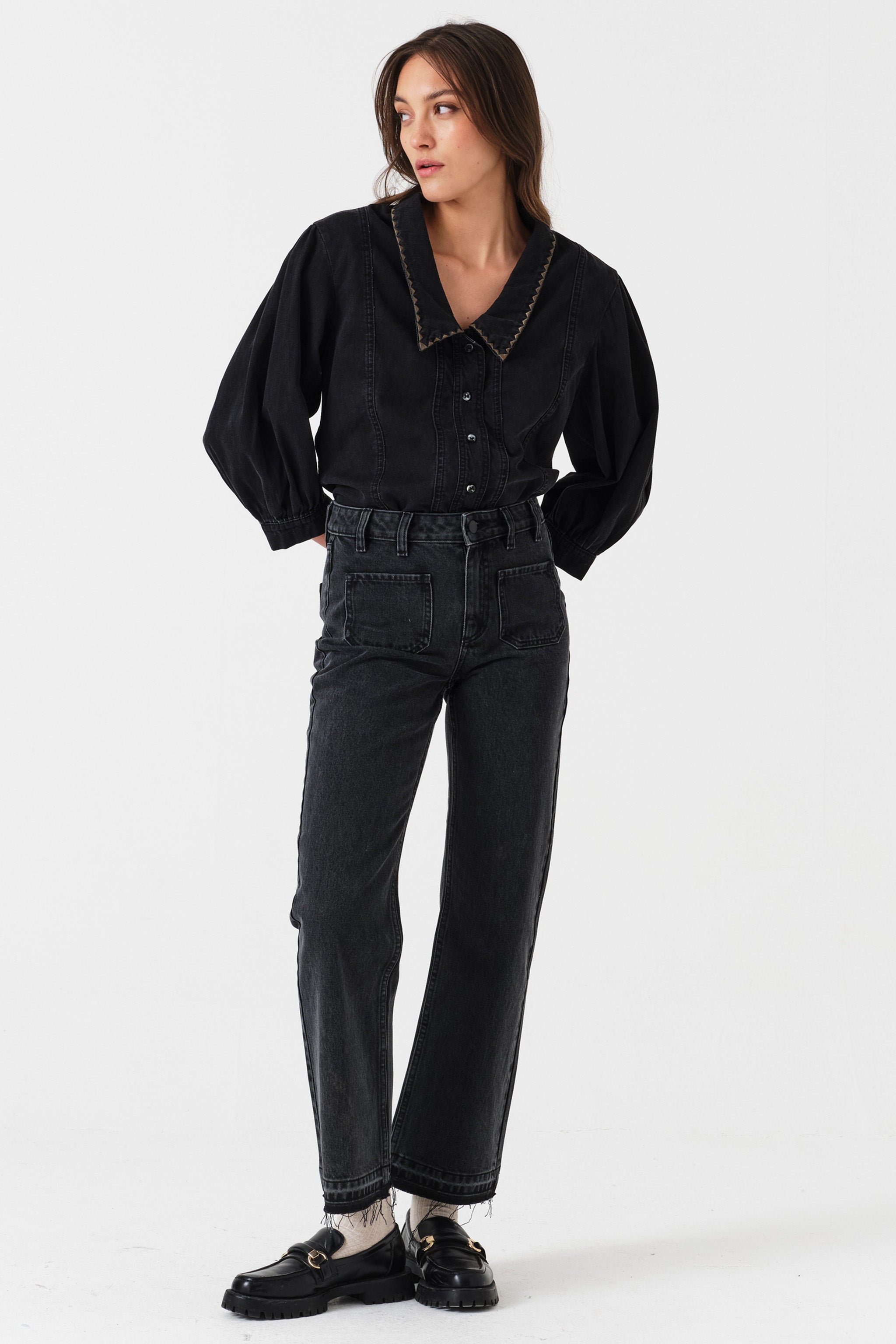 Woman wearing a black denim button up shirt paired with washed black jeans