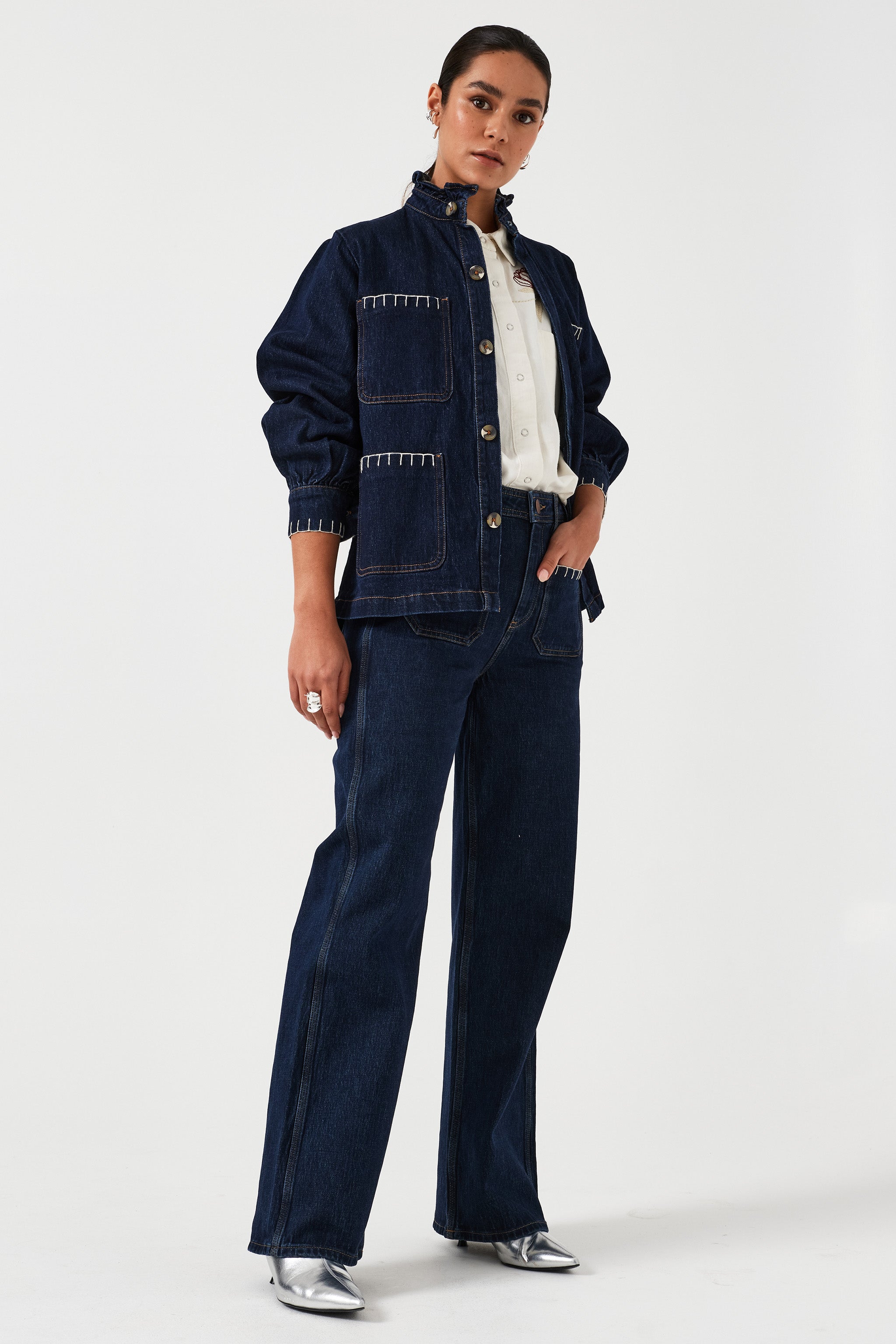 Woman wearing a dark blue denim jacket paired with its matching dark vintage wide leg jean.