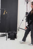 woman holding a black denim dress / long jacket with silver studs (embellishments) and a tailored cinched waist 